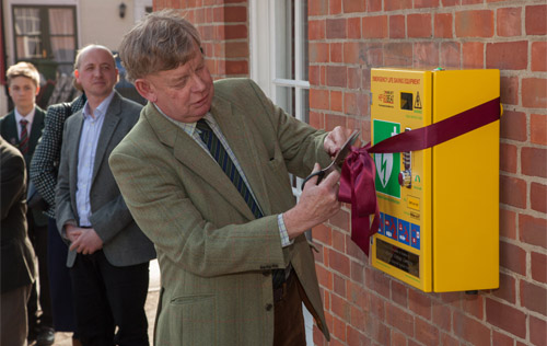 Norfolk Police and Crime Commissioner Stephen Bett unveils the defibrillator watched by James Ellis, business development director, The Original Cottage Company. Photos: John Tym