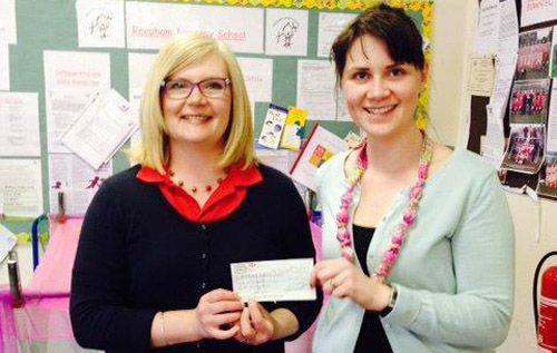 Reepham Nursery School supervisor Rachael Jones (left) receives a cheque for '£150 from Amy Loxton of Butler & Castell