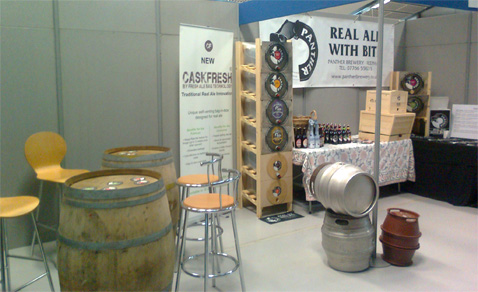 Panther Brewery's stand at the Norfolk Catering & Hospitality Expo 2013 showing the evolution of ale containers ' wooden, stainless steel, plastic and the new Caskfresh, shown in the six-high shelving unit