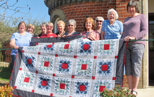 Members of the Reepham-based Oak Leaf Quilters with their teenage quilt for Project Linus UK