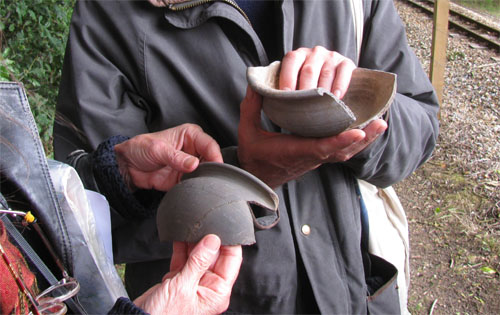 Participants on a World Tree archaeological guided walk handling Roman pottery