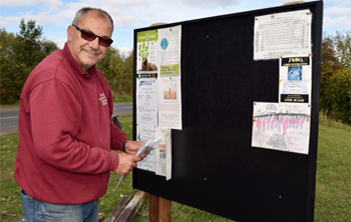 Clive Hall puts the finishing touches to the new Station Plain noticeboard. Photo: Charles Butcher