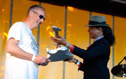 Kev Hickman accepting the guitar on behalf of Mark Kovacevic from Pauline Black, lead singer of The Selecter