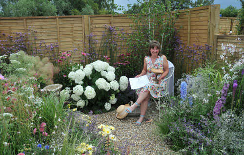 Dominique Rudd pictured in her award-wining Garden Of Tranquillity with the Gold certificate and trophy for EDP for Best in Show at the Sandringham Flower Show. Photo: Kevin Myhill